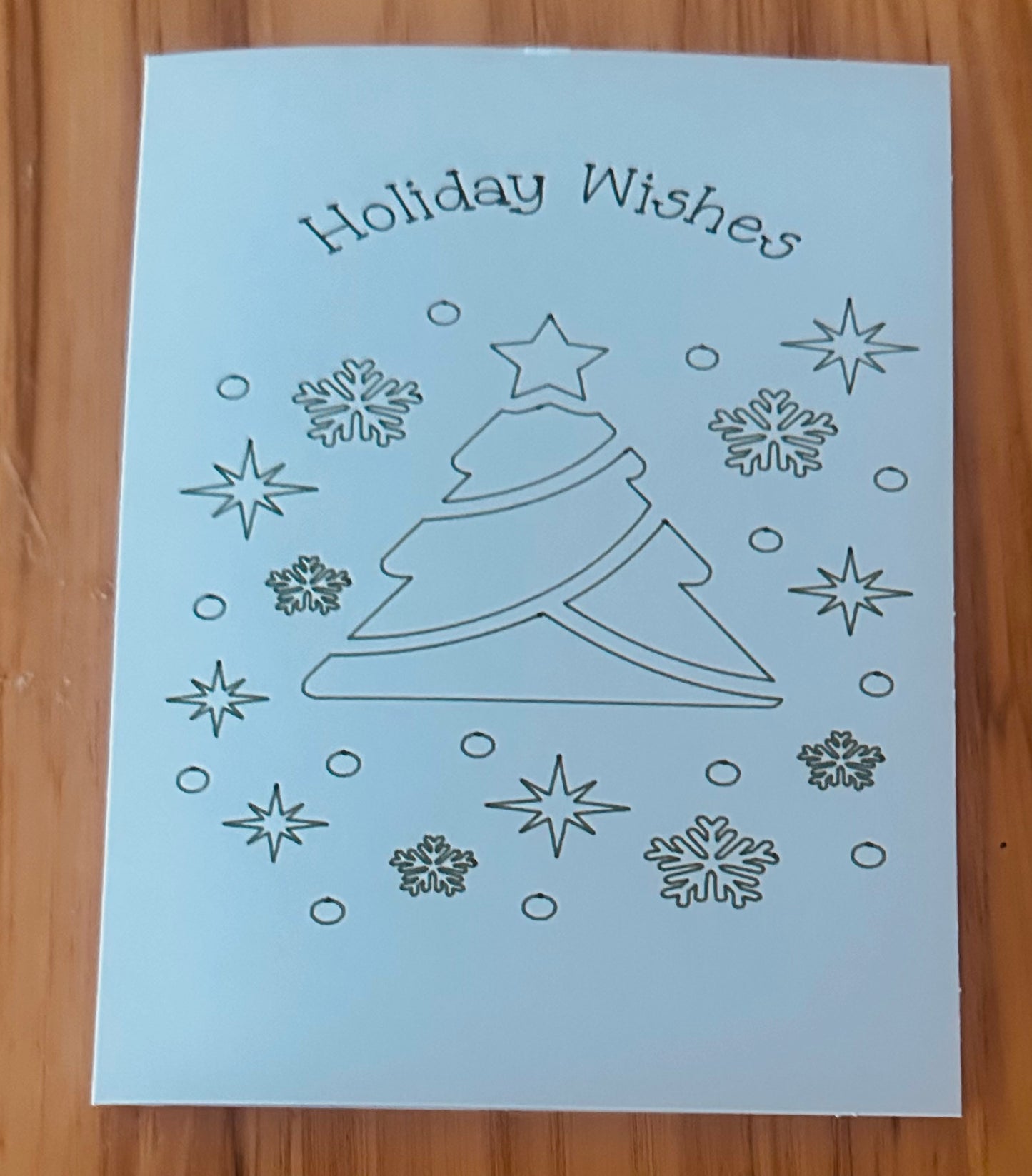 Send warm Holiday Wishes with this beautifully handmade greeting card!
Featuring a modern Christmas tree design surrounded by stars and snow